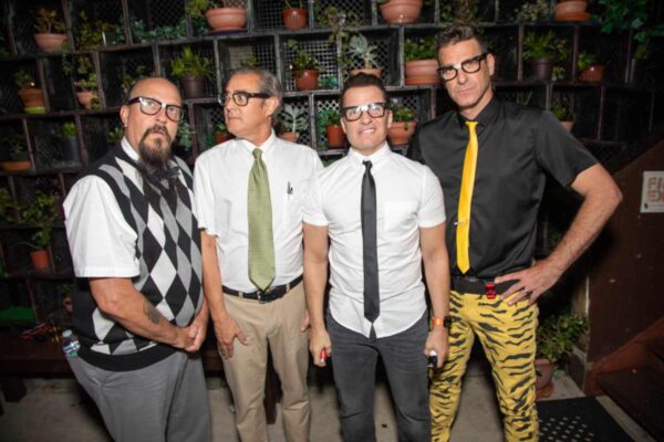 Nerd Halen band members gather on the outdoor patio at Bottom of The Hill in San Francisco, California, after their performance. The night scene is set against a backdrop of lush plants.